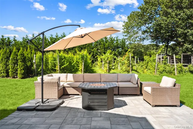 a view of a patio with a table and chairs under an umbrella