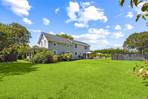 a view of a house with a big yard and a large tree