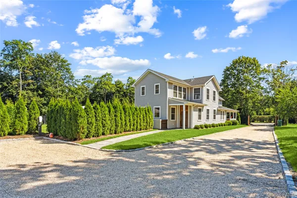 a view of a big house with a big yard and large trees