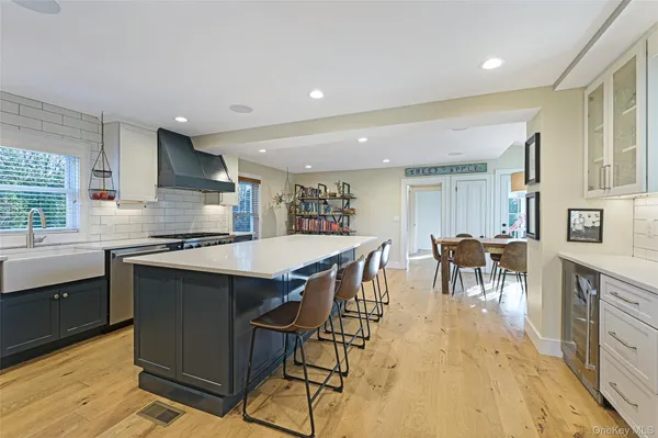a kitchen with stainless steel appliances granite countertop table chairs sink and cabinets