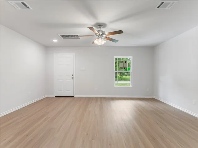 wooden floor in an empty room with a window