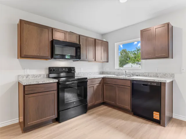 a kitchen with stainless steel appliances granite countertop a stove microwave and sink