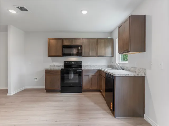 a kitchen with a sink stove and microwave