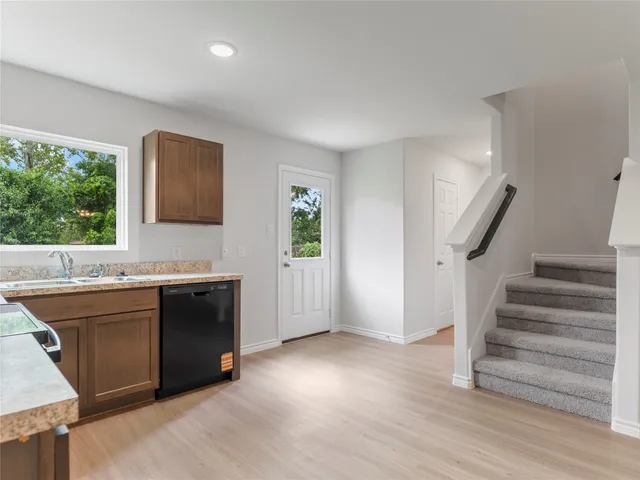 a view of a kitchen with wooden floor and electronic appliances