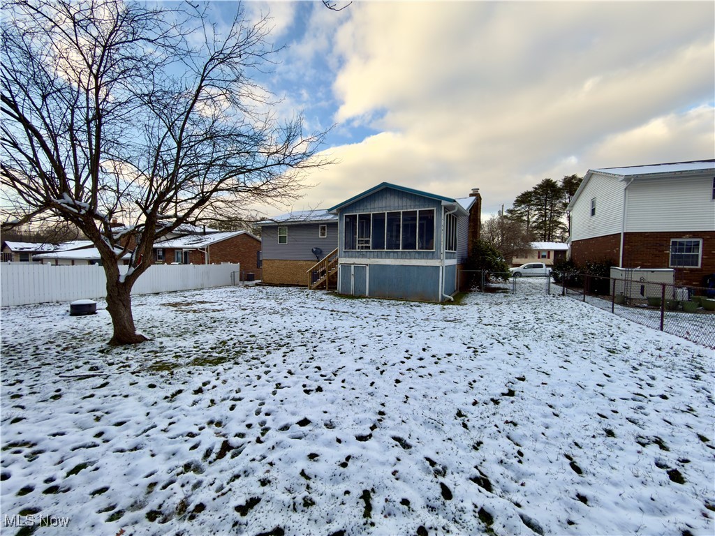 43 Romine Road Washington, WV 26181 - Photo 26 of 30 Snow covered rear of property featuring a fenced backyard and a sunroom