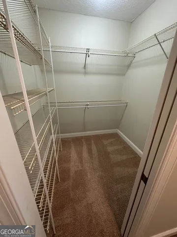 en empty room with windows and chandelier fan