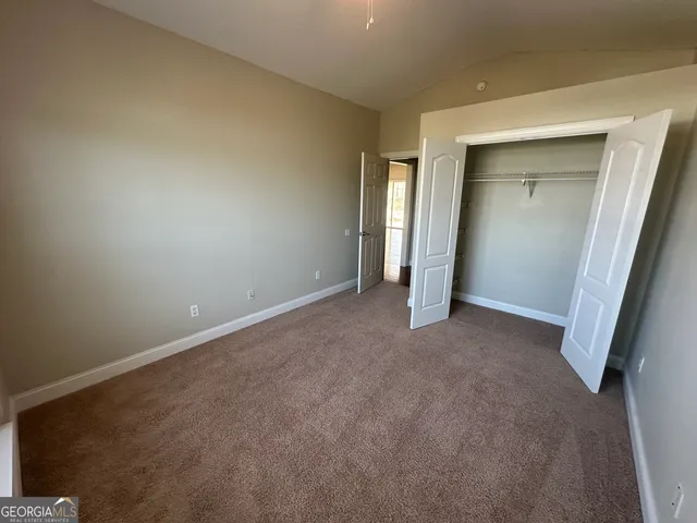 an empty room with closet and wooden door