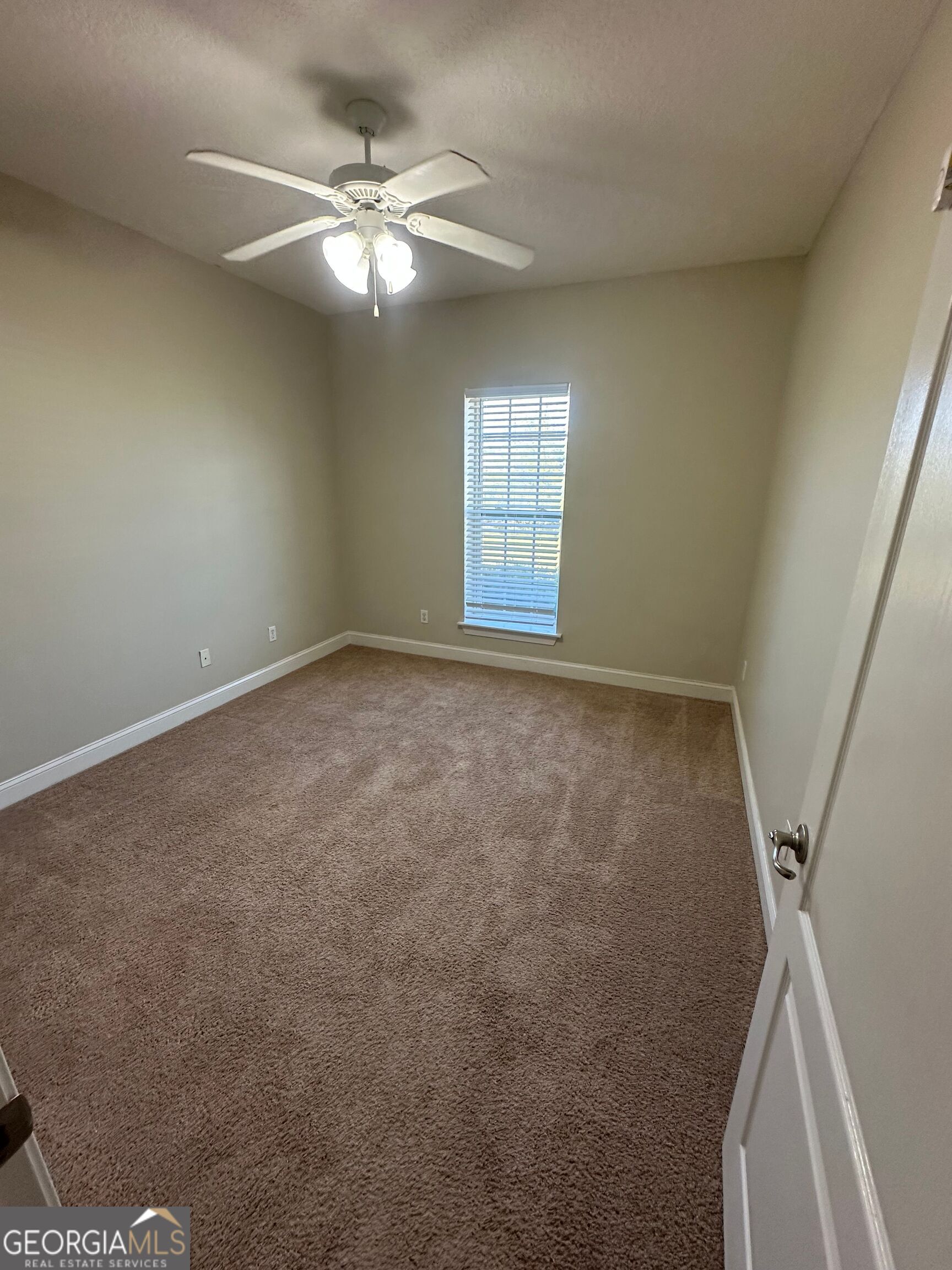 39 Coastal Walk St. Marys, GA 31558 - Photo 9 of 23 an empty room with windows and fan