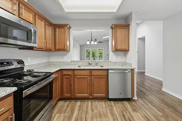 a kitchen with stainless steel appliances granite countertop a stove a sink and a microwave