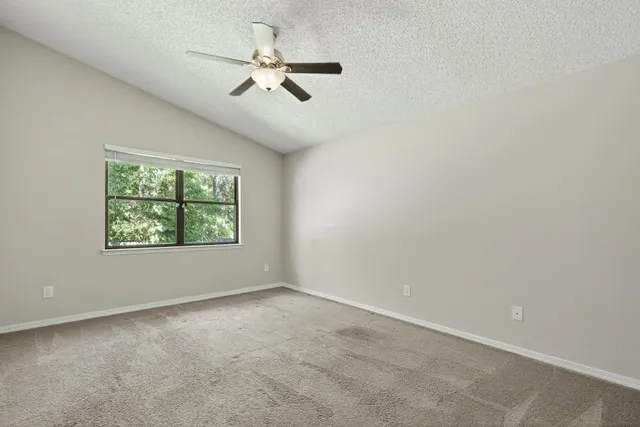 an empty room with closet and a chandelier fan