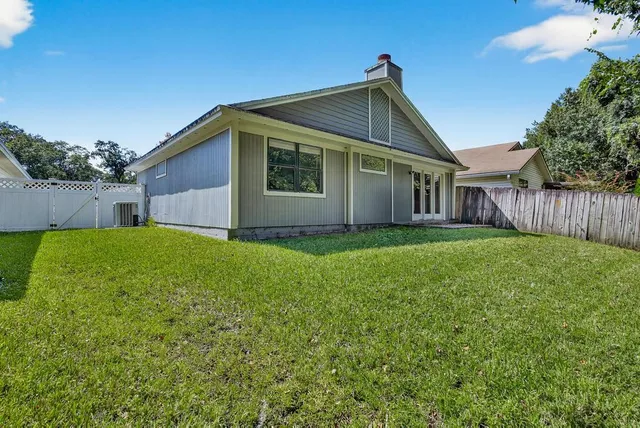 a view of backyard with wooden fence