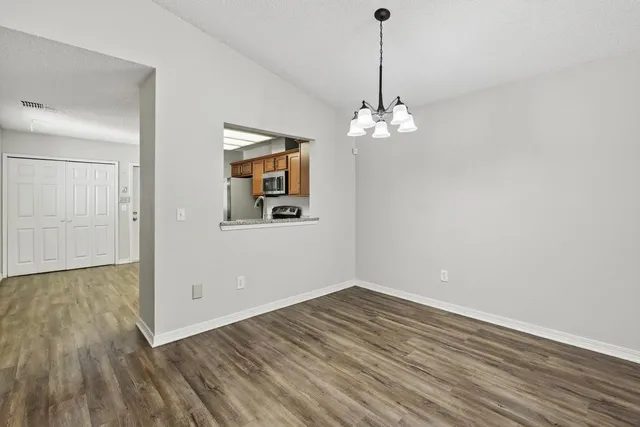 a view of a room with wooden floor chandelier and window