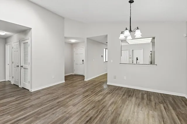 a view of empty room with wooden floor and ceiling fan