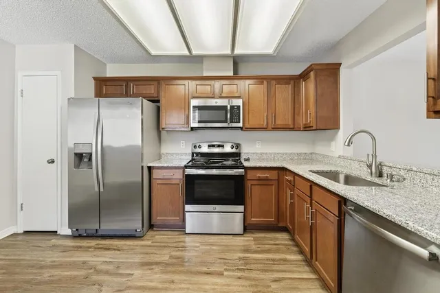 a kitchen with stainless steel appliances granite countertop a stove a sink and a refrigerator