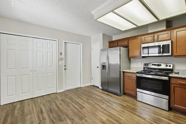a kitchen with stainless steel appliances granite countertop a refrigerator and a stove top oven