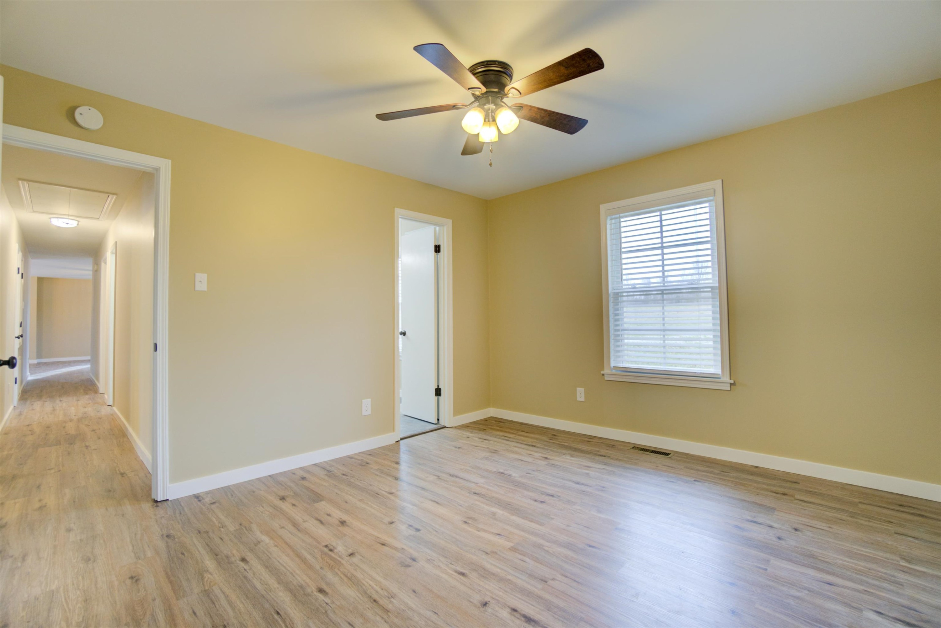 430 Teacher Road Lavinia, TN 38348 - Photo 7 of 20 a view of an empty room with wooden floor and a window