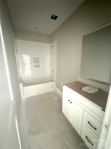 a bathroom with a tub sink and mirror