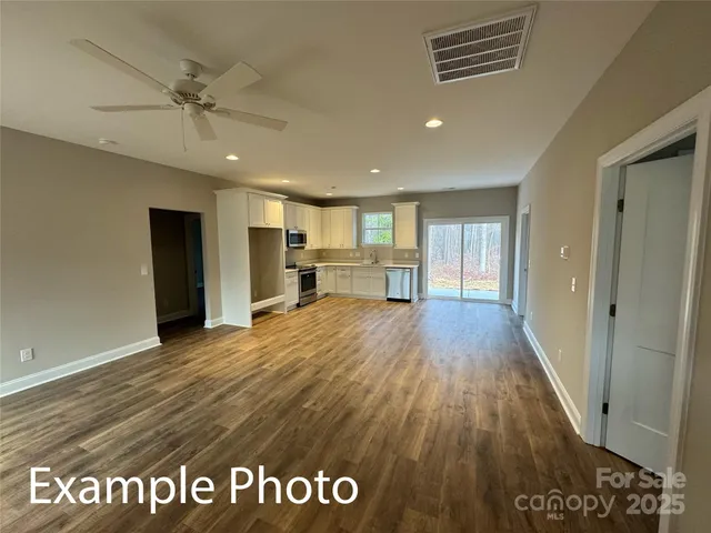 a view of kitchen with sink and refrigerator