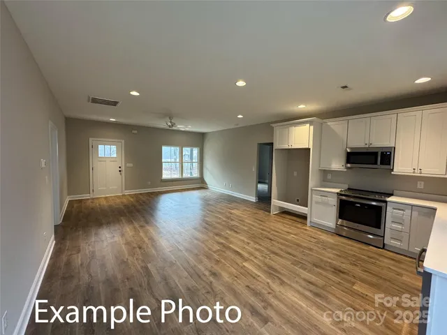 a view of kitchen with stainless steel appliances granite countertop a refrigerator and a sink
