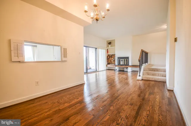 a view of a livingroom with wooden floor and a ceiling fan