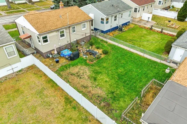 a view of a house with a big yard plants and large trees