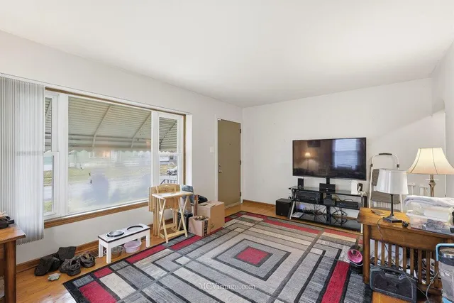 a living room with furniture a flat screen tv and a table