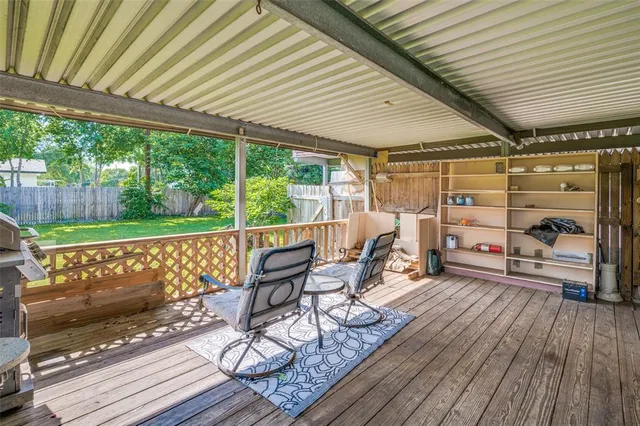 a roof deck with table and chairs and wooden floor