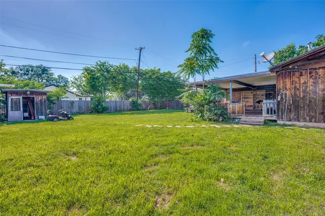a view of a house with a yard and potted plants