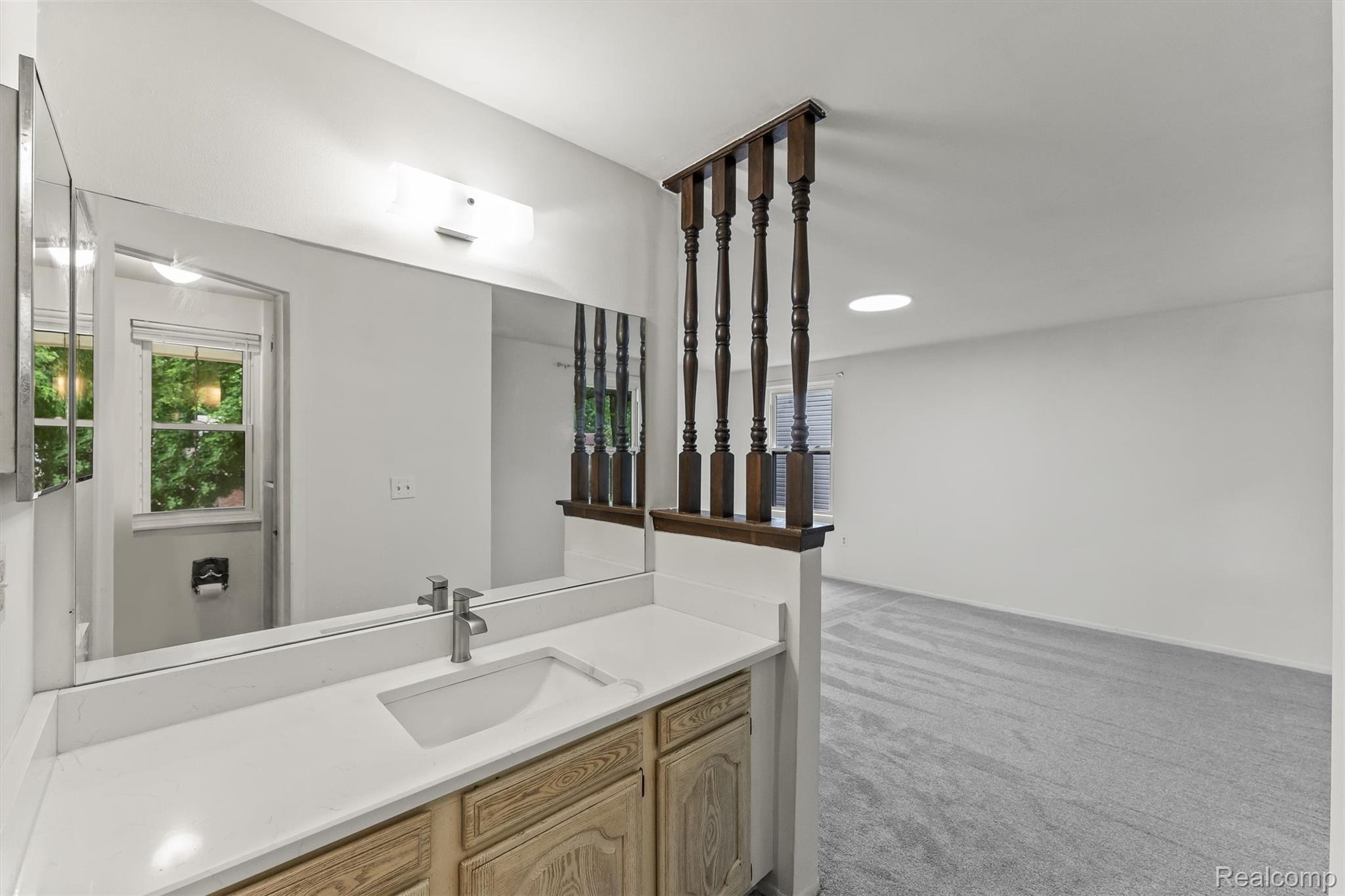 2118 Rutgers Drive Troy, MI 48085 - Photo 24 of 39 Vanity area featuring a single basin sink, light-toned cabinetry, and a large mirror