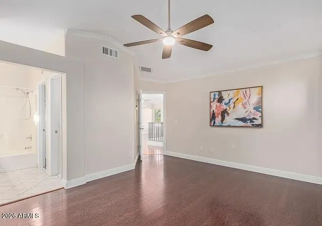 an empty room with wall painting and a ceiling fan