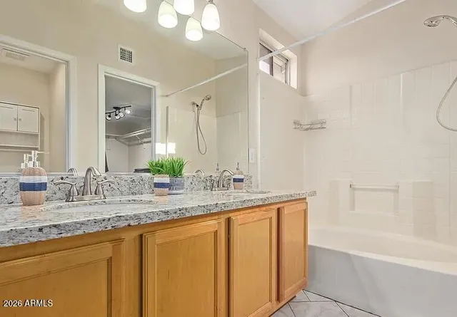 a bathroom with a granite countertop sink mirror and a bathtub