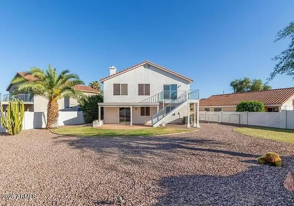 a view of a house with a yard and palm trees