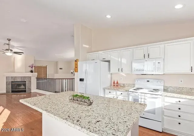 a kitchen with granite countertop white cabinets and stainless steel appliances