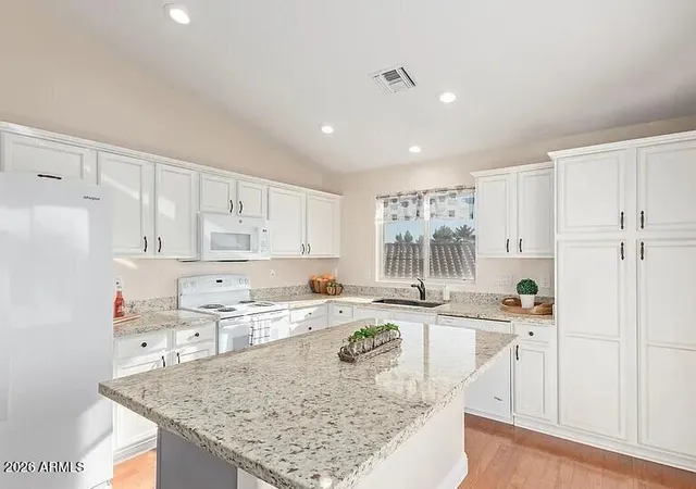 a kitchen with stainless steel appliances granite countertop a sink stove and white cabinets