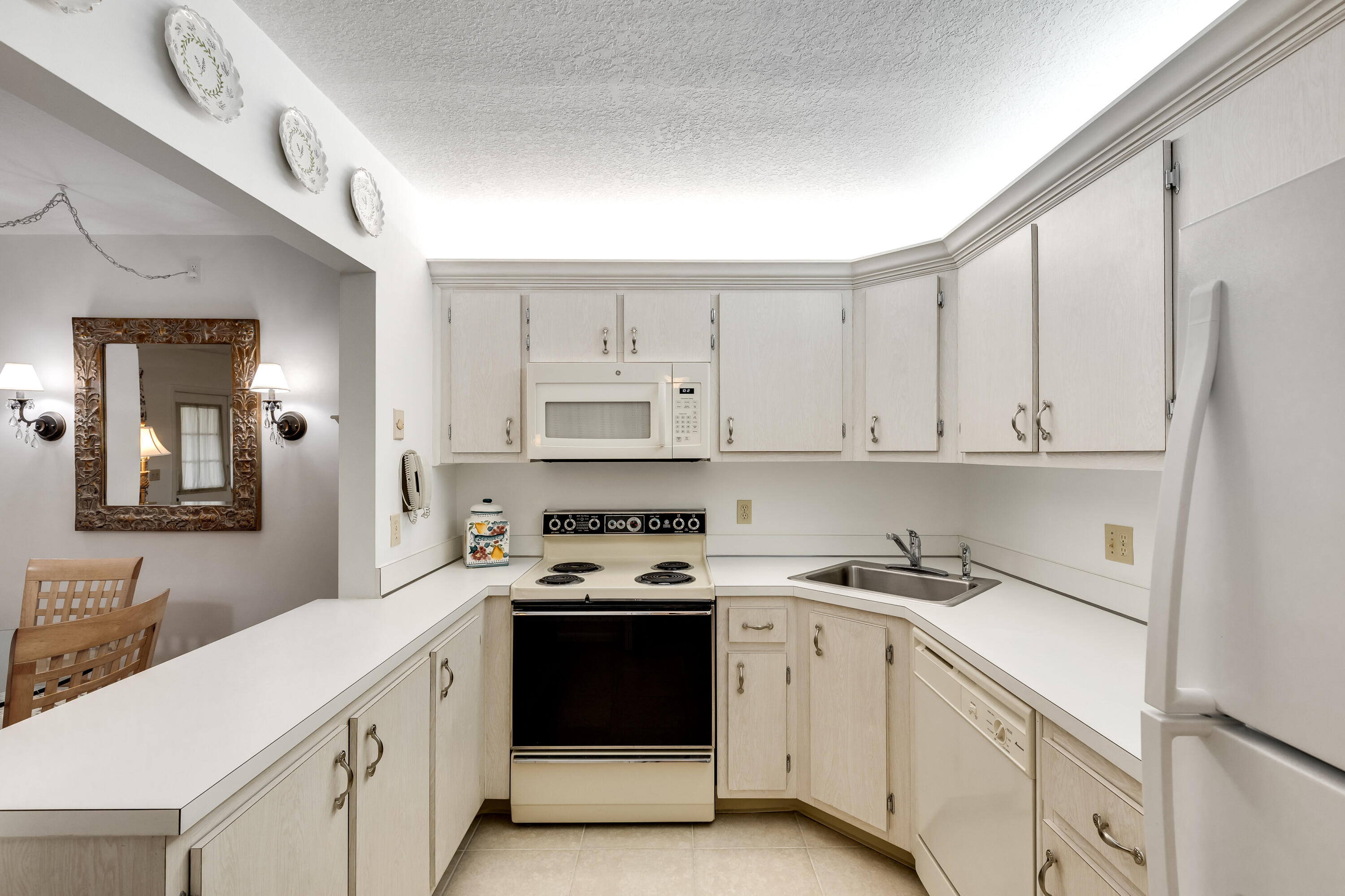 122 Lake Pine Circle, Unit B1 Greenacres, FL 33463 - Photo 15 of 36 a kitchen with cabinets appliances a sink and a counter top space