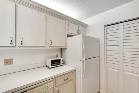 a kitchen with a refrigerator and cabinets