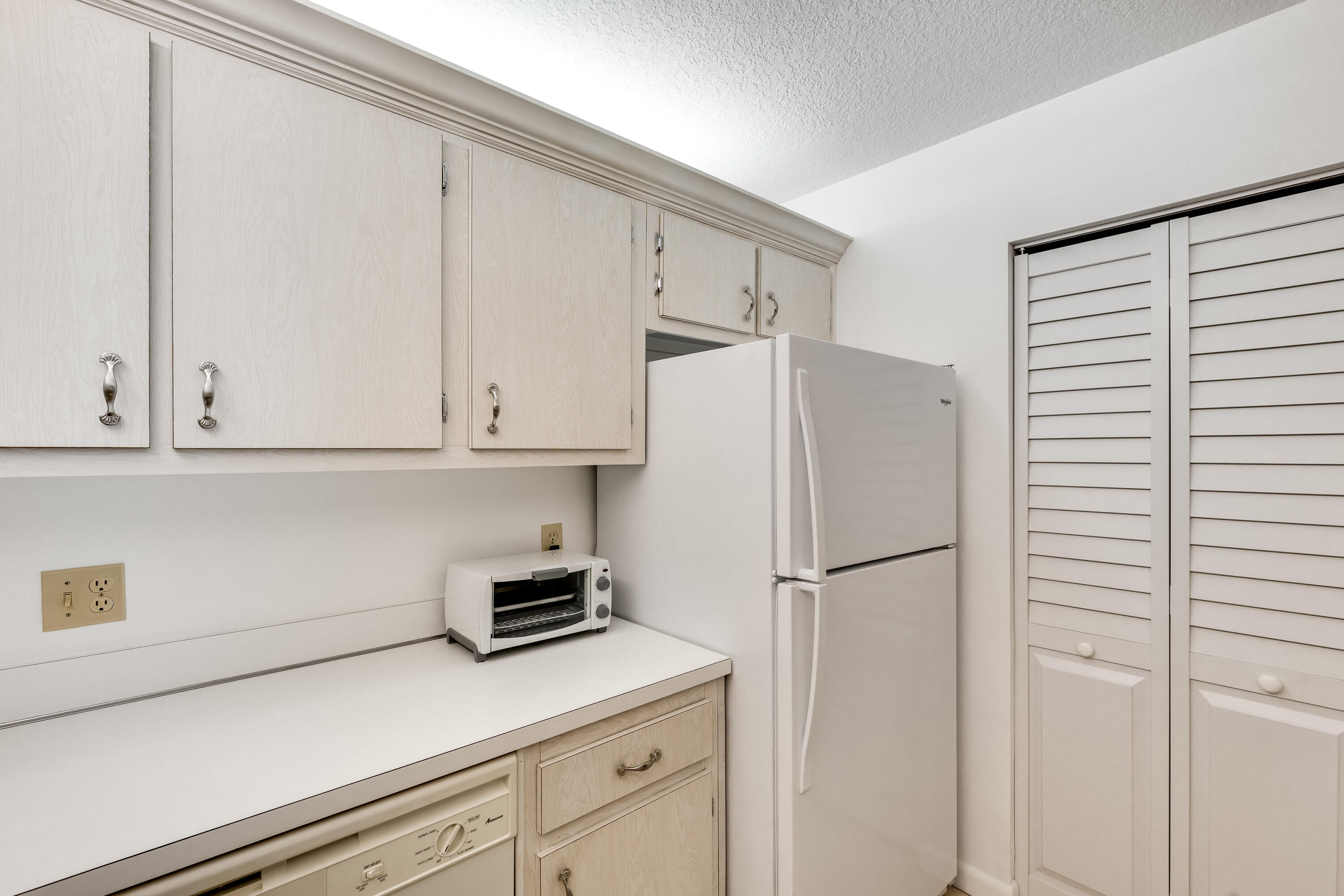 122 Lake Pine Circle, Unit B1 Greenacres, FL 33463 - Photo 16 of 36 a kitchen with a refrigerator and cabinets