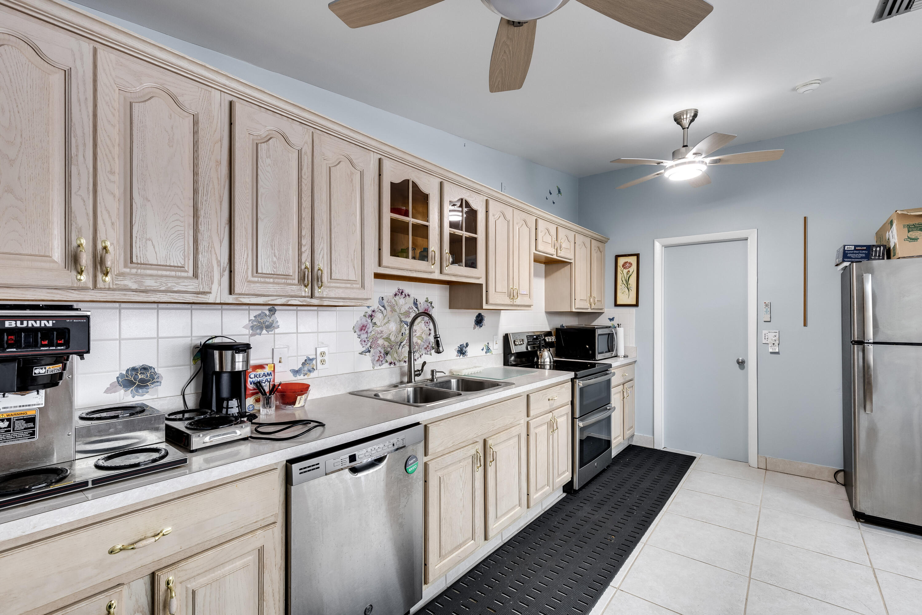 122 Lake Pine Circle, Unit B1 Greenacres, FL 33463 - Photo 32 of 36 a kitchen with stainless steel appliances a sink stove and refrigerator