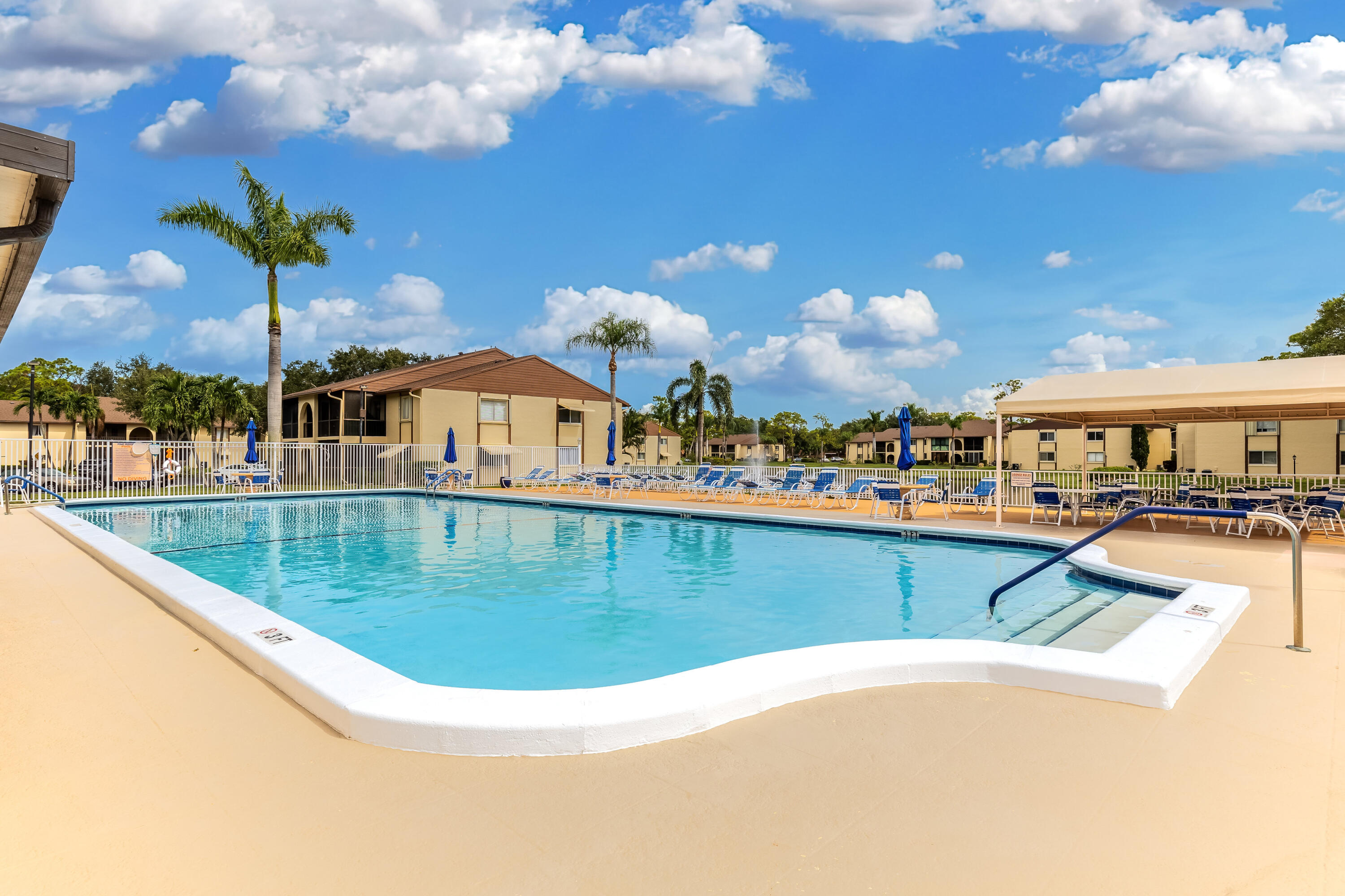 122 Lake Pine Circle, Unit B1 Greenacres, FL 33463 - Photo 33 of 36 a view of a swimming pool with outdoor seating