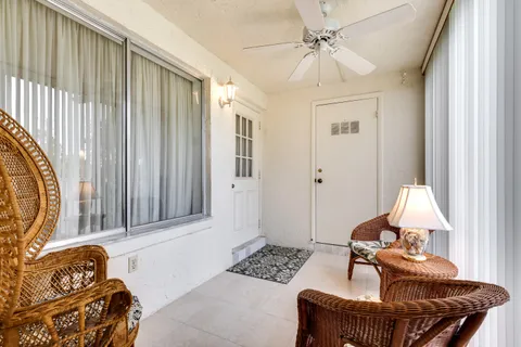 a living room with patio furniture and a floor to ceiling window