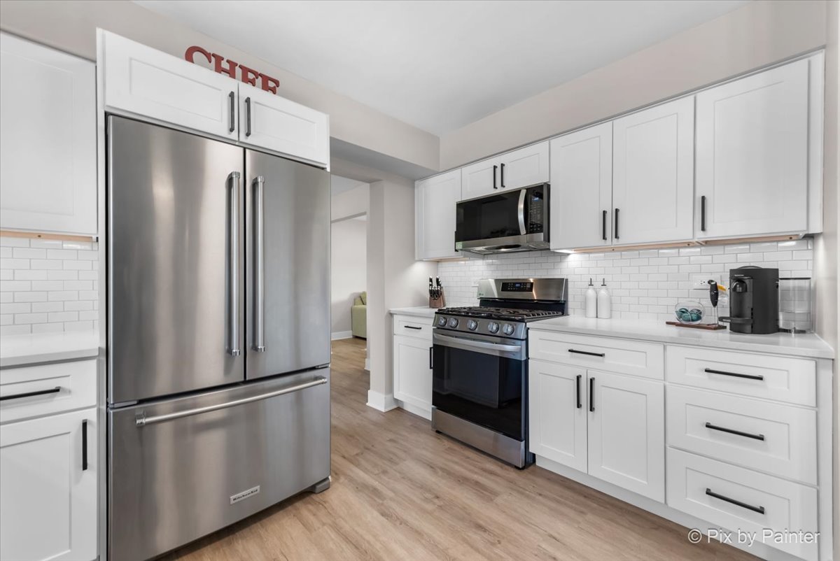 906 Edward Street Wheeling, IL 60090 - Photo 10 of 34 a kitchen with stainless steel appliances a refrigerator stove and white cabinets