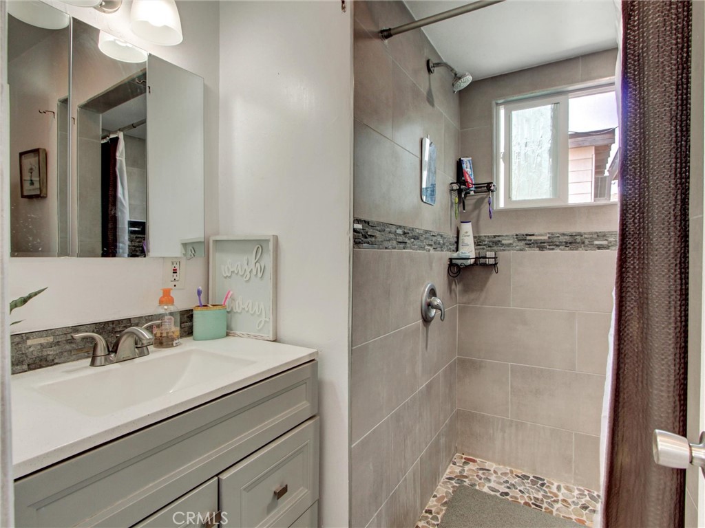 10922 Vickers Drive Garden Grove, CA 92840 - Photo 17 of 25 a bathroom with a sink and mirror with bathtub