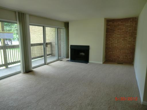 5880 Forest View Road, Unit B Lisle, IL 60532 - Photo 6 of 15 a view of an empty room with a fireplace and a window