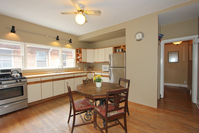 311 South Ridgeland Avenue Oak Park, IL 60302 - Photo 11 of 25 a kitchen with stainless steel appliances granite countertop a stove top oven a refrigerator a sink and dishwasher with wooden floor