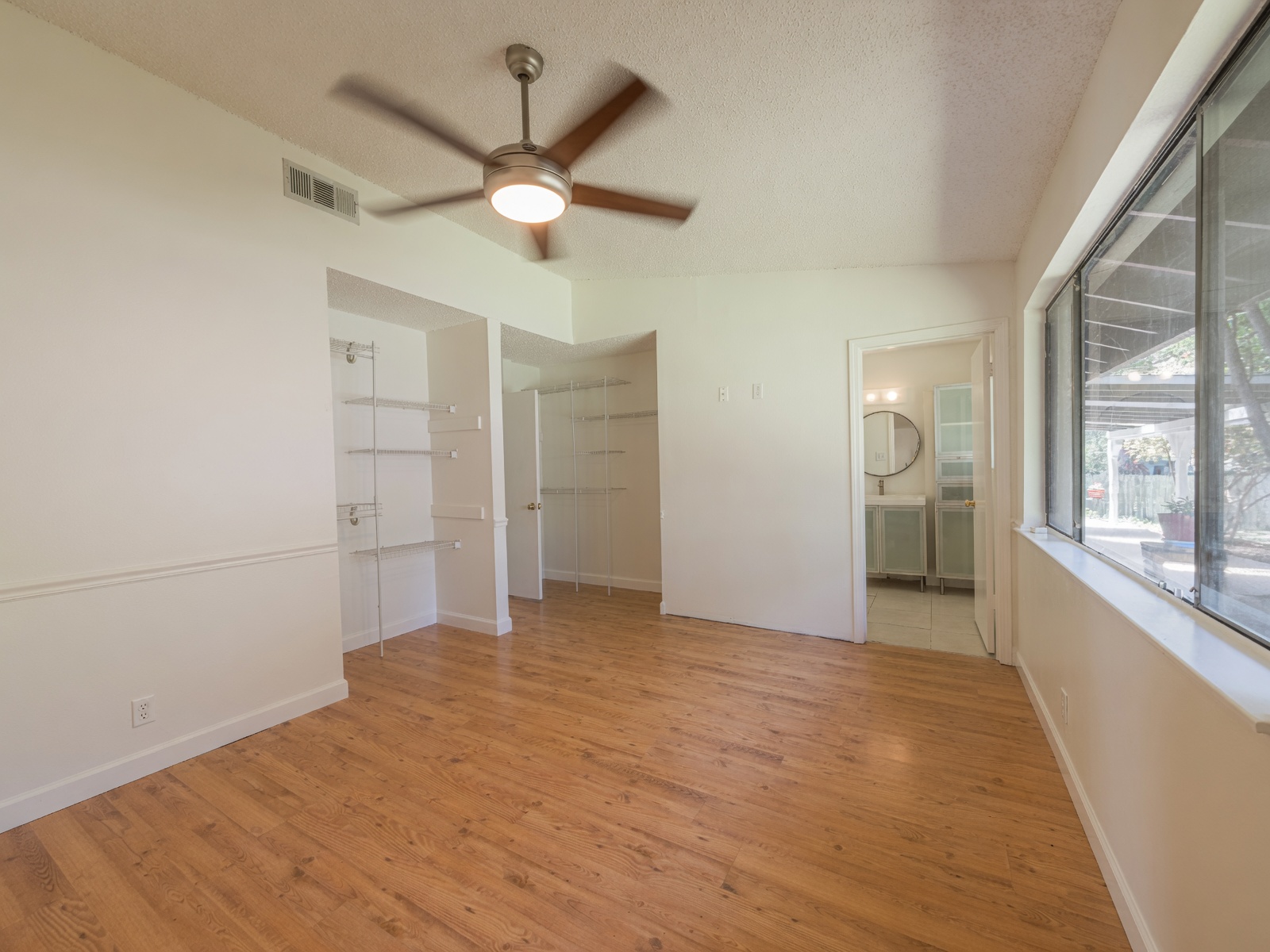5310 Presidio Road Austin, TX 78745 - Photo 14 of 31 Primary bedroom features built-in shelving, and a ceiling fan, offering a clear view of the adjacent bath.