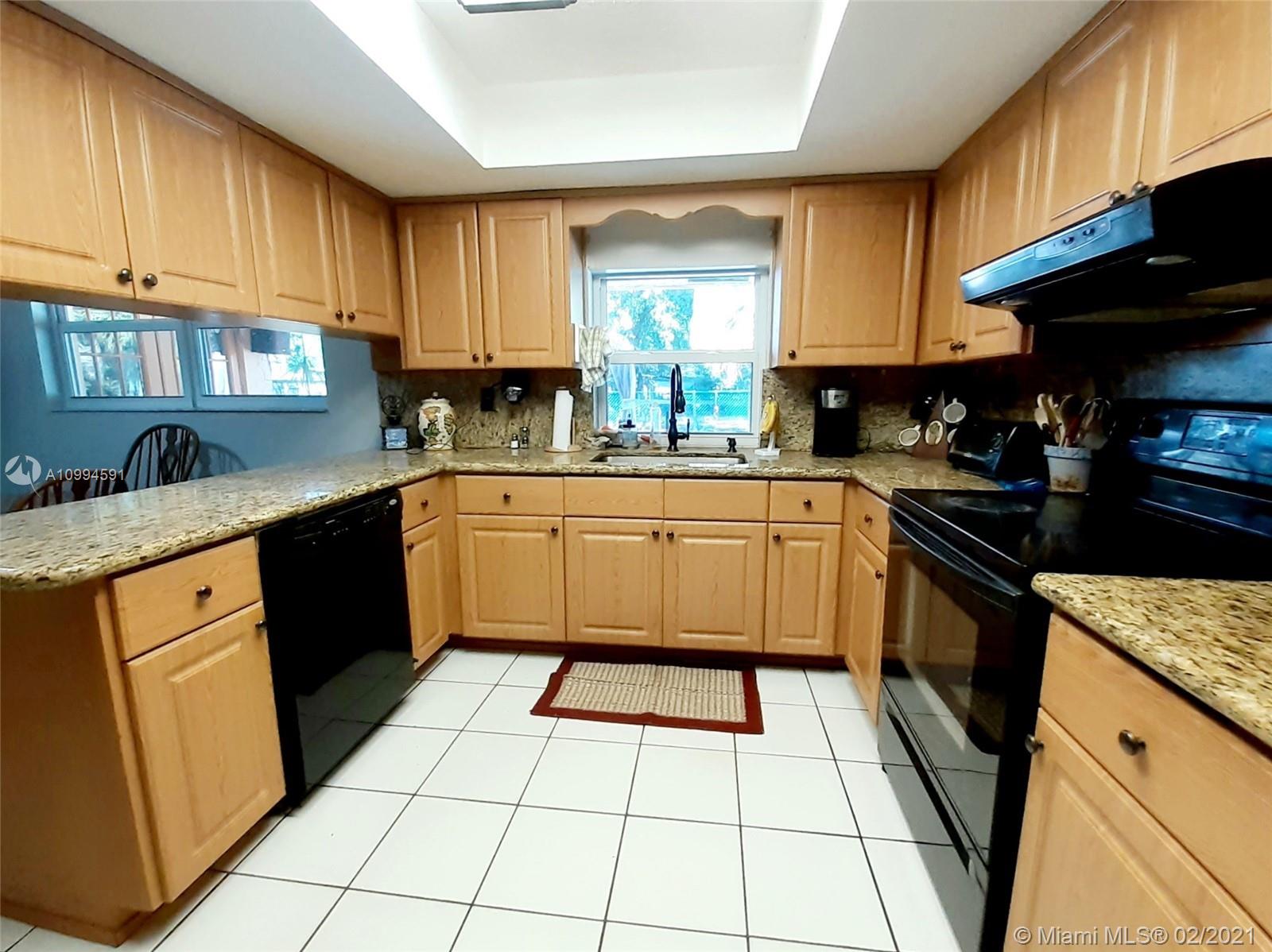6301 Southwest 186th Way Southwest Ranches, FL 33332 - Photo 8 of 29 a kitchen with a sink a stove top oven a refrigerator and cabinets