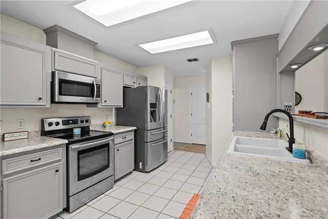 a kitchen with stainless steel appliances granite countertop a stove a sink and a refrigerator