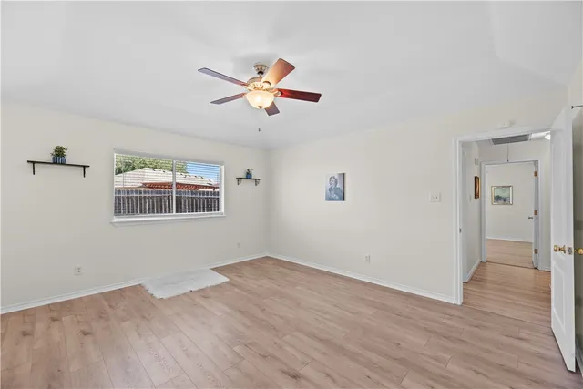 a view of a room with wooden floor and a ceiling fan