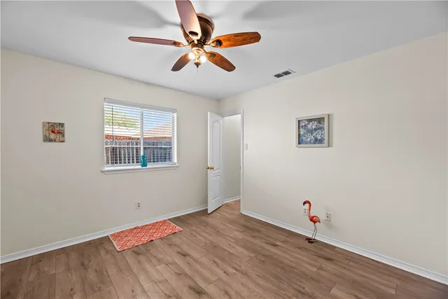 a view of a big room with wooden floor and windows