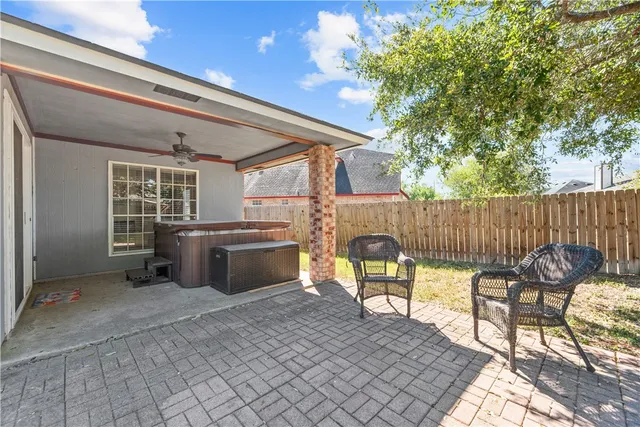 a view of a patio with table and chairs and wooden fence